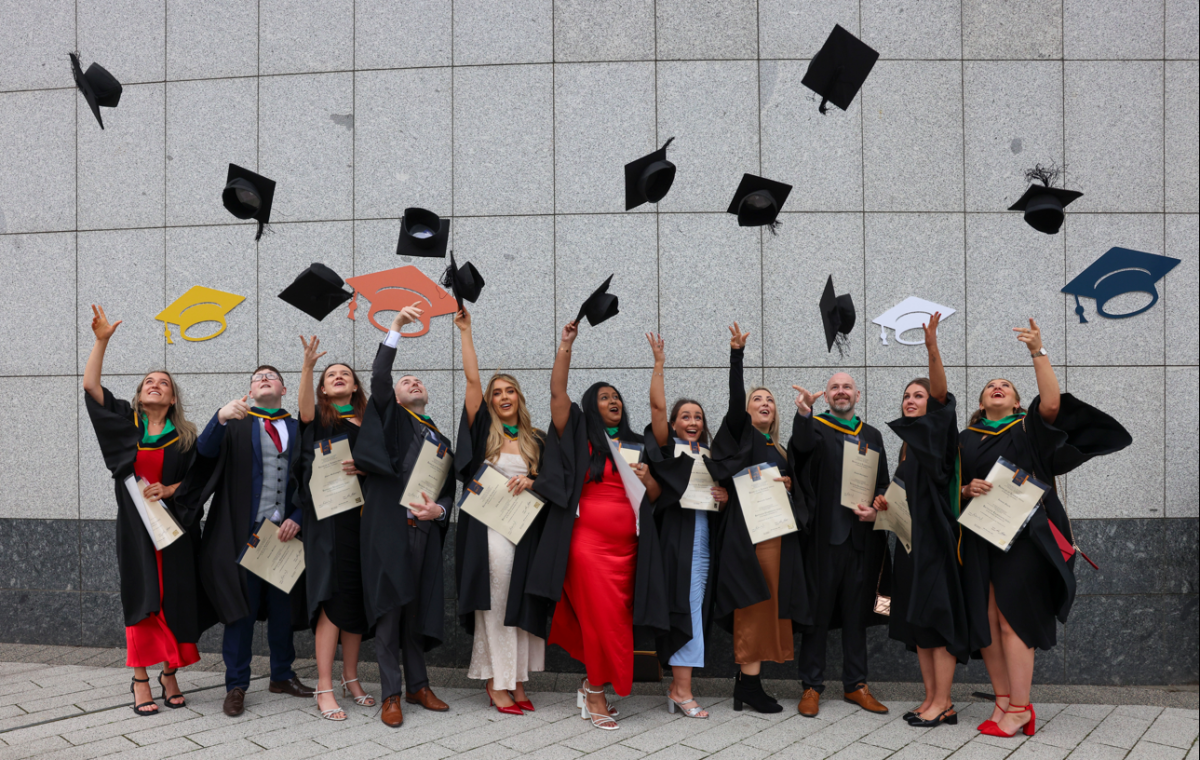 Group of graduates throwing their caps