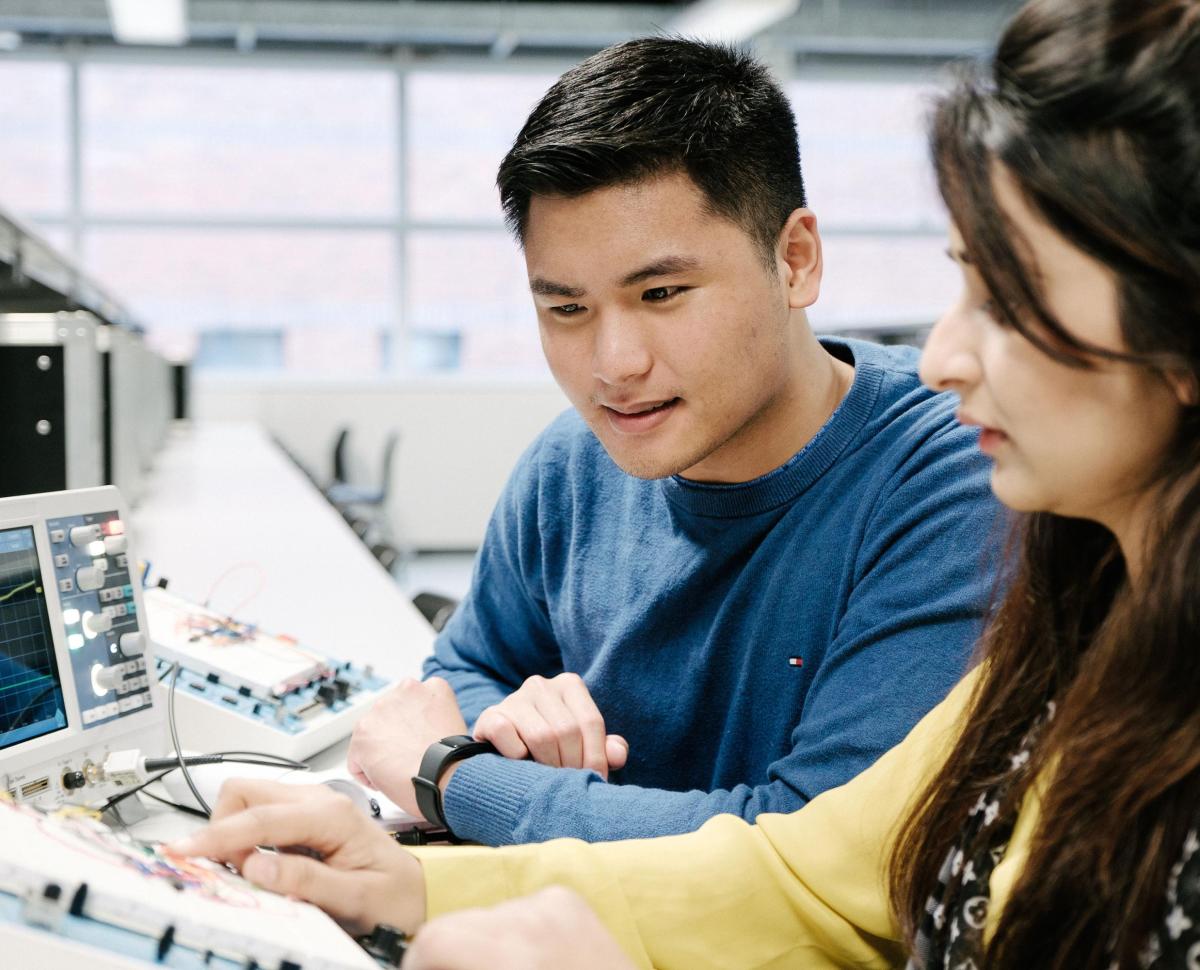 two students working together in a computer lab 