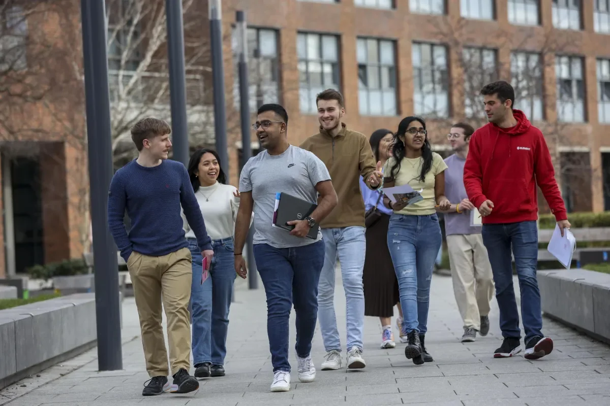 6 students walking through campus