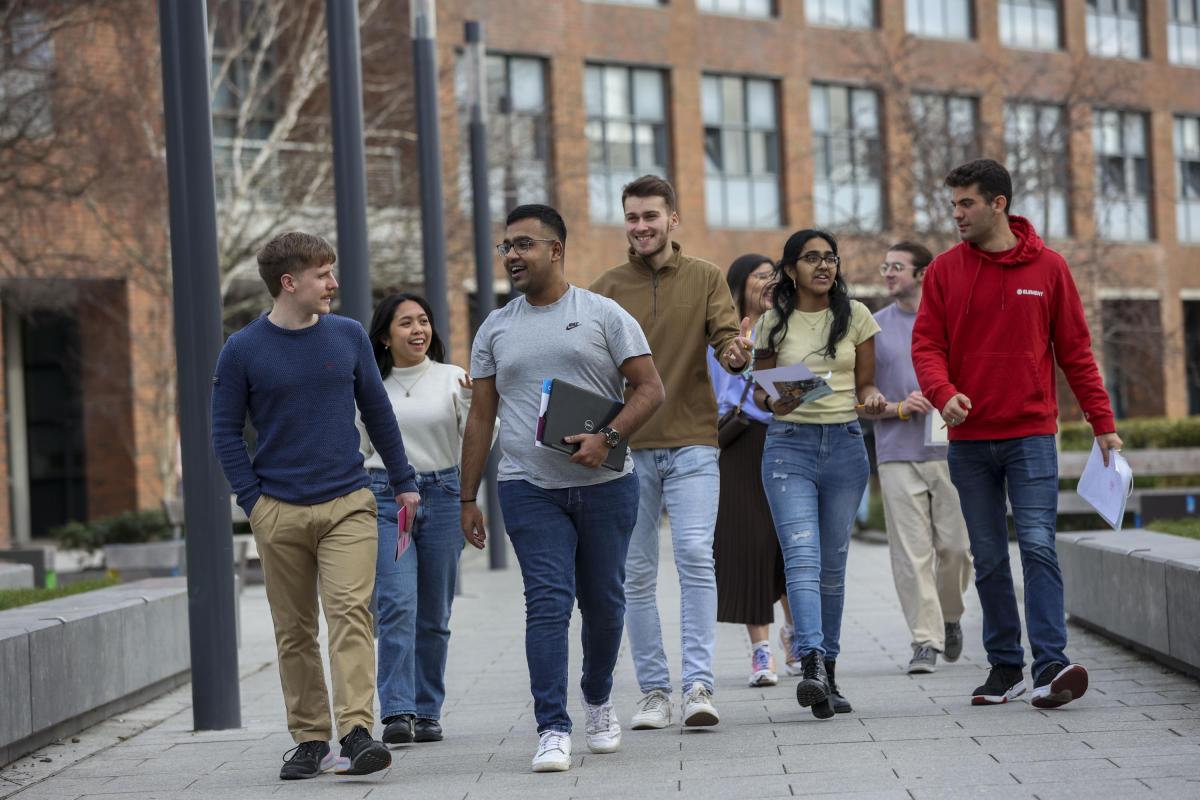 6 students walking through campus