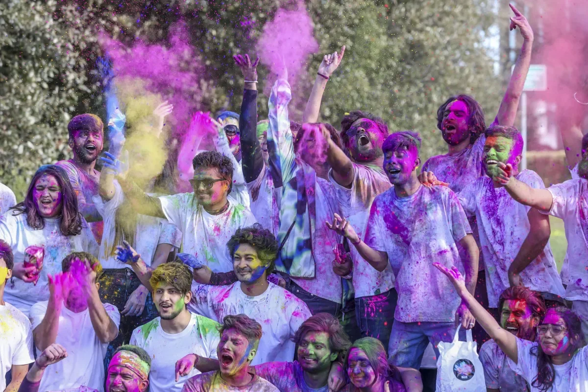 Student pictured with holi powdered colours on face
