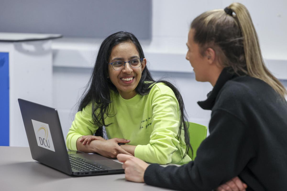 Students work together on a laptop