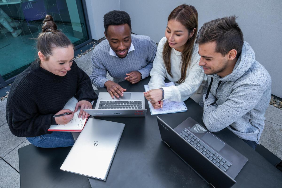 This image shows students working together at a desk