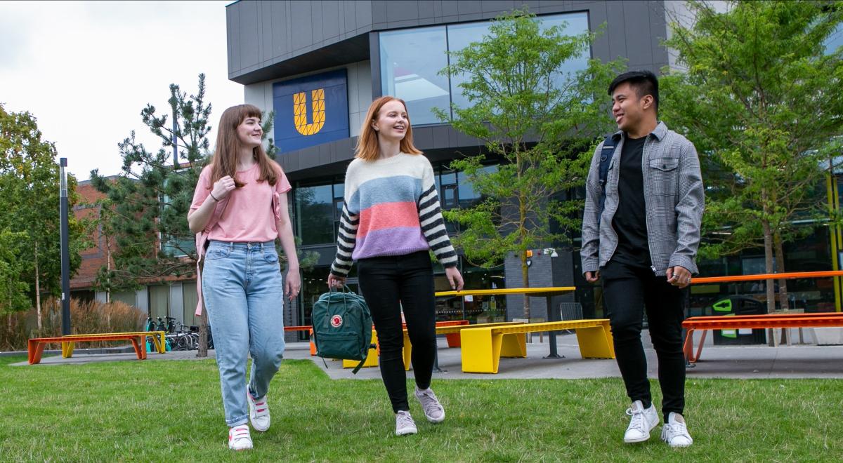 Image of three students walking around campus