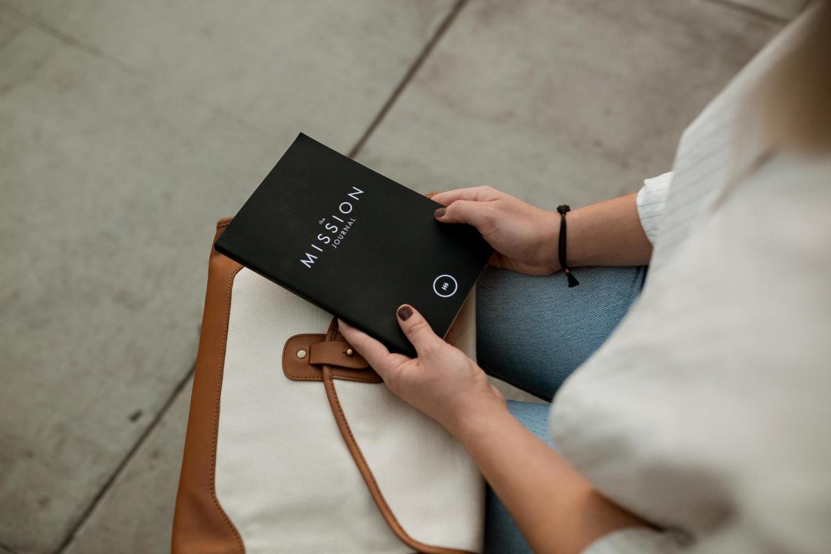 woman sitting with notebook entitled Mission