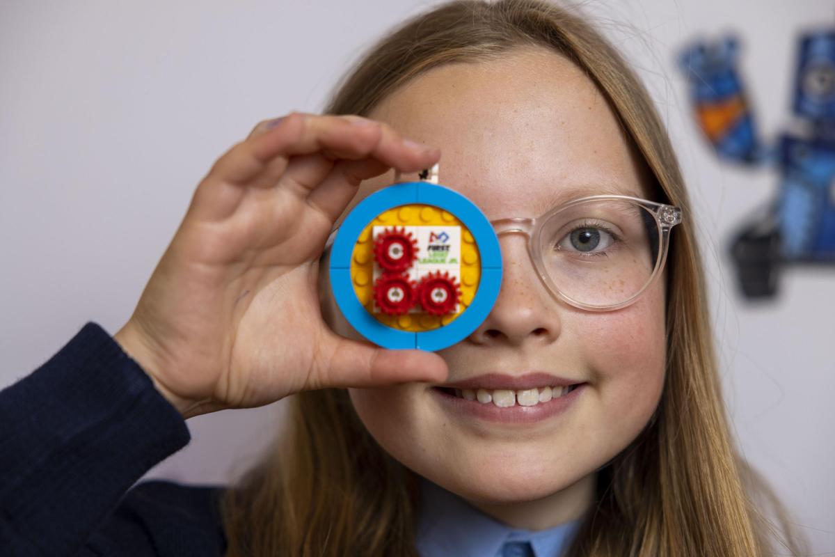 A participating student holds up Lego covering her eye at the Superpowered event