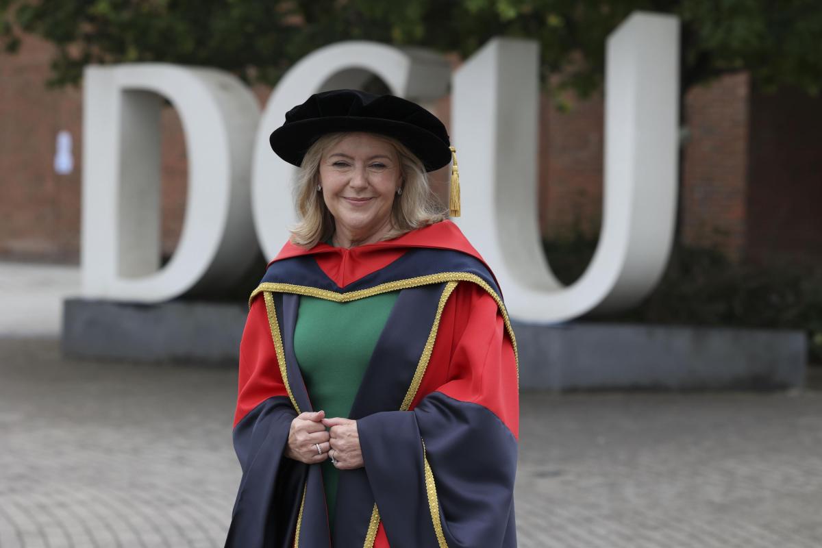 Rosaleen Blair standing in front of the DCU letters