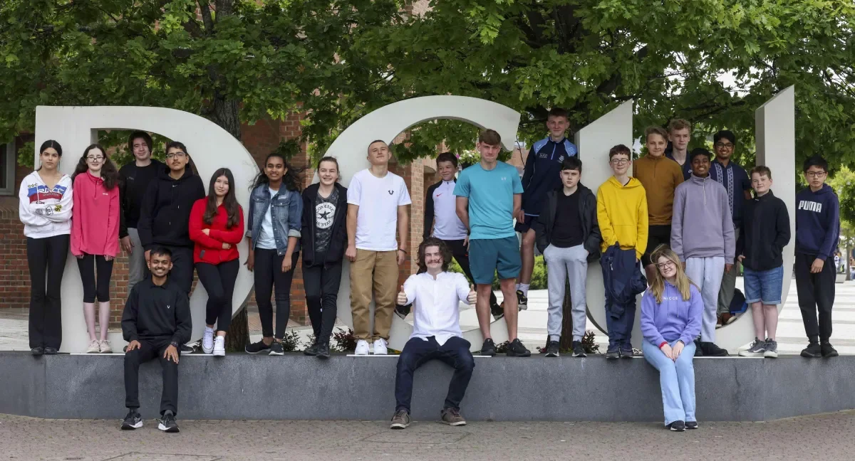 This image shows secondary school students attending EE camp at the DCU sign