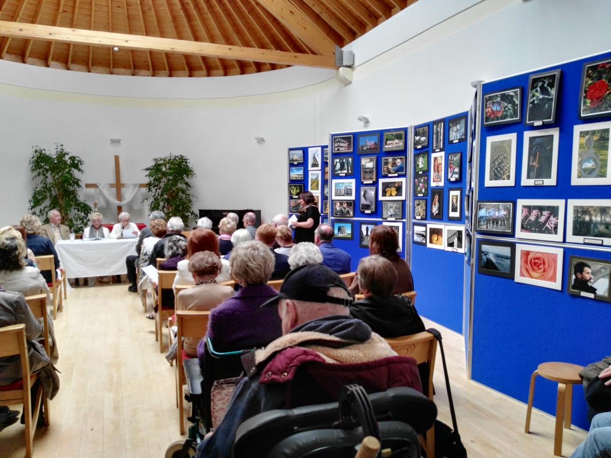 audience of listeners in the Interfaith centre with photo exhibition