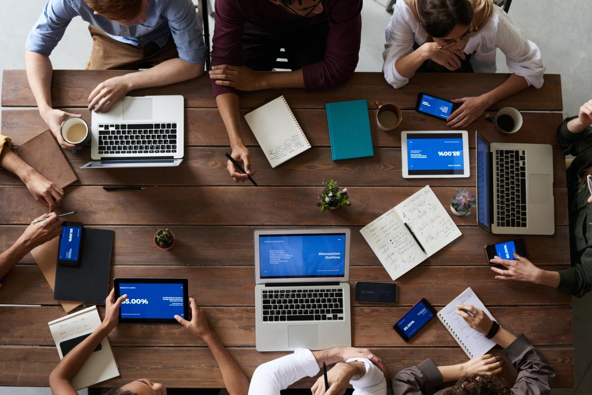 Team around table with tech devices