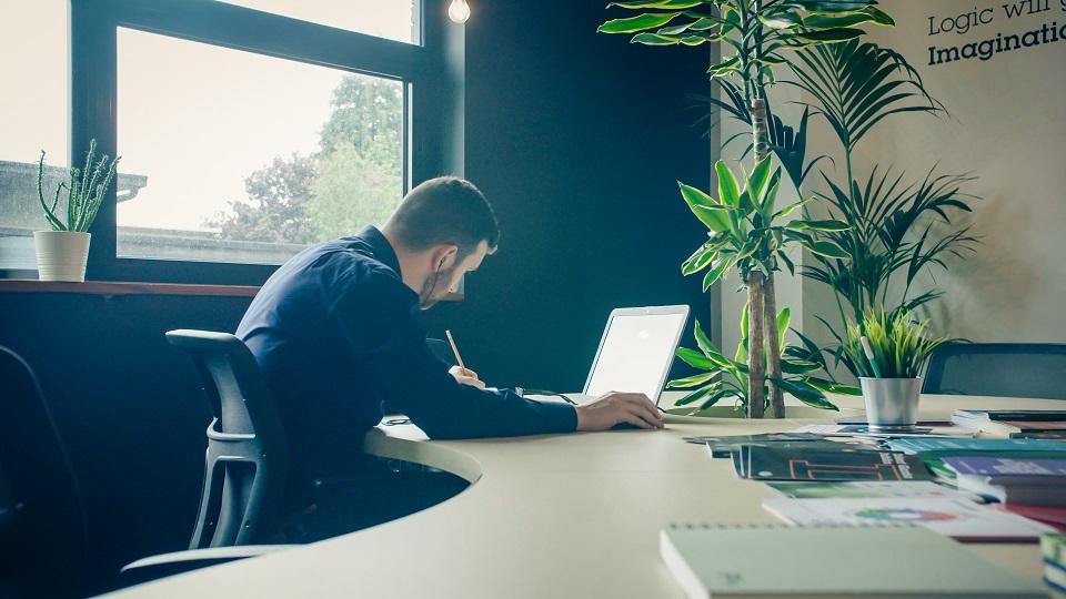 A man sitting at a desk working on his computer.