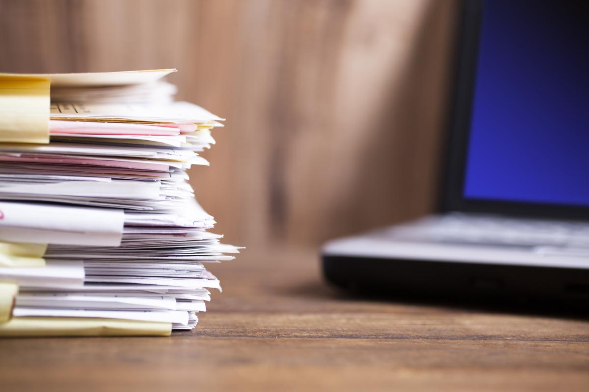 files stacked in front of a laptop computer