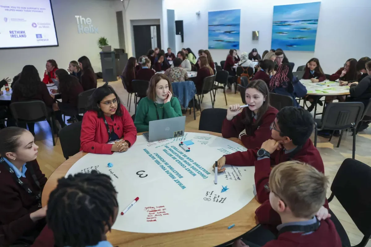 Students and teachers around a table discussing bullying
