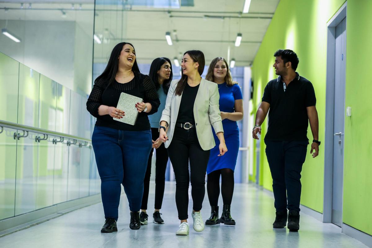 Postgraduate students walking down a hall