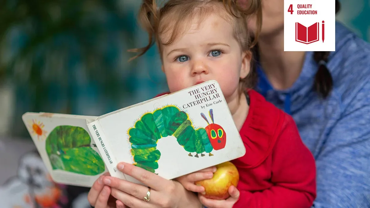 Shows child reading book with parent and a white icon signifying United Nations sustainable development goal four