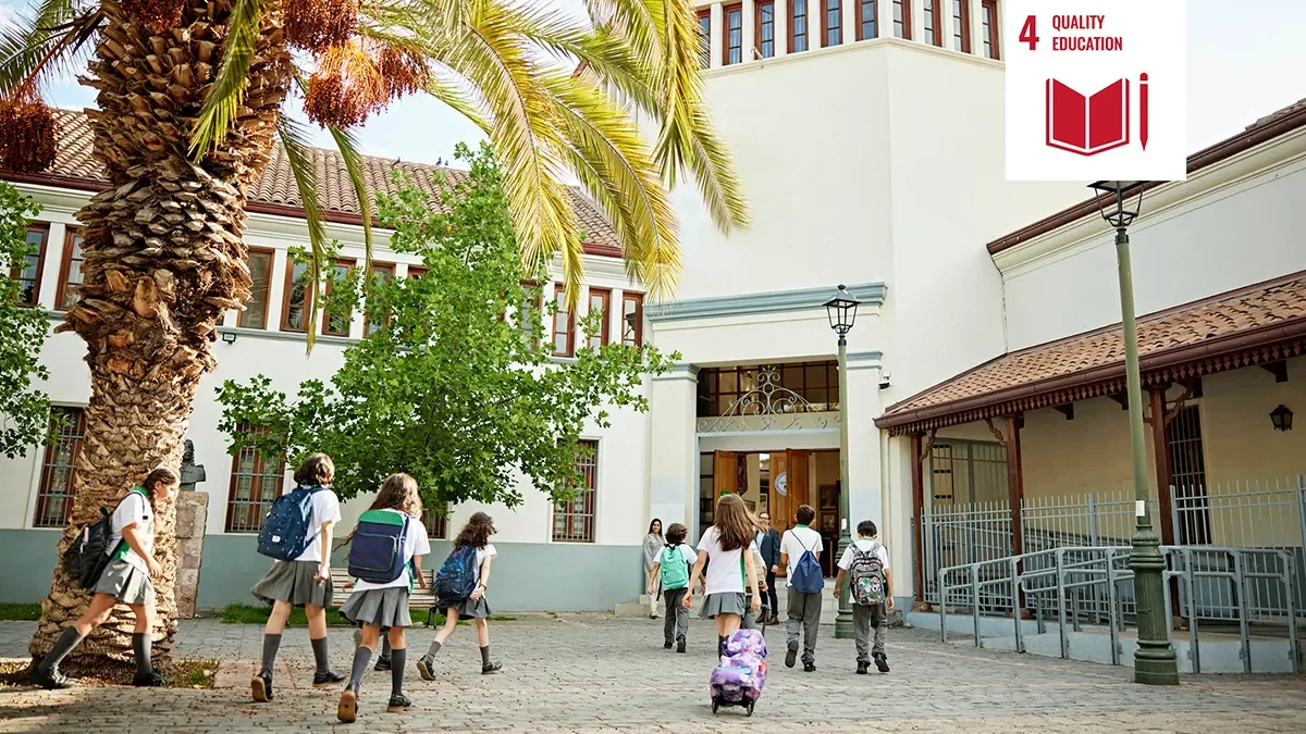 Shows children entering school in Malta with white icon signifying United Nations Sustainability goal four
