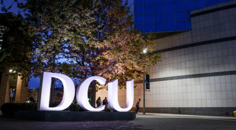 Shows the DCU letters sign on the Glasnevin campus at night