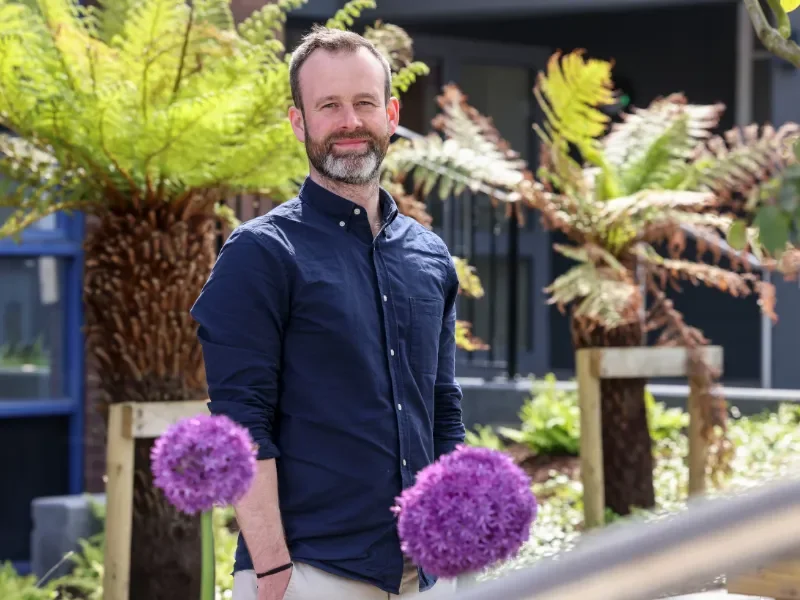 Shows Dr Jimmy O'Keeffe posing amongst plants on DCU's Glasnevin campus