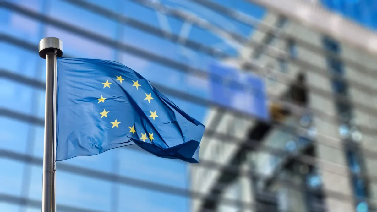 Shows European Union flag flying outside the European Commission's headquarters in Brussels