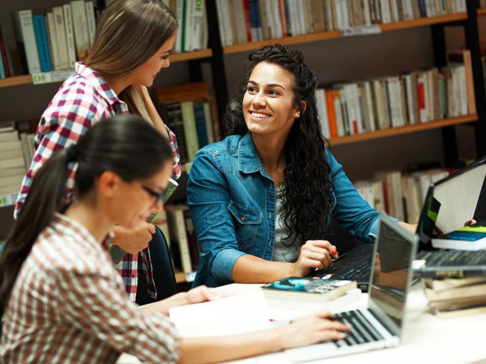 Three students working in a library