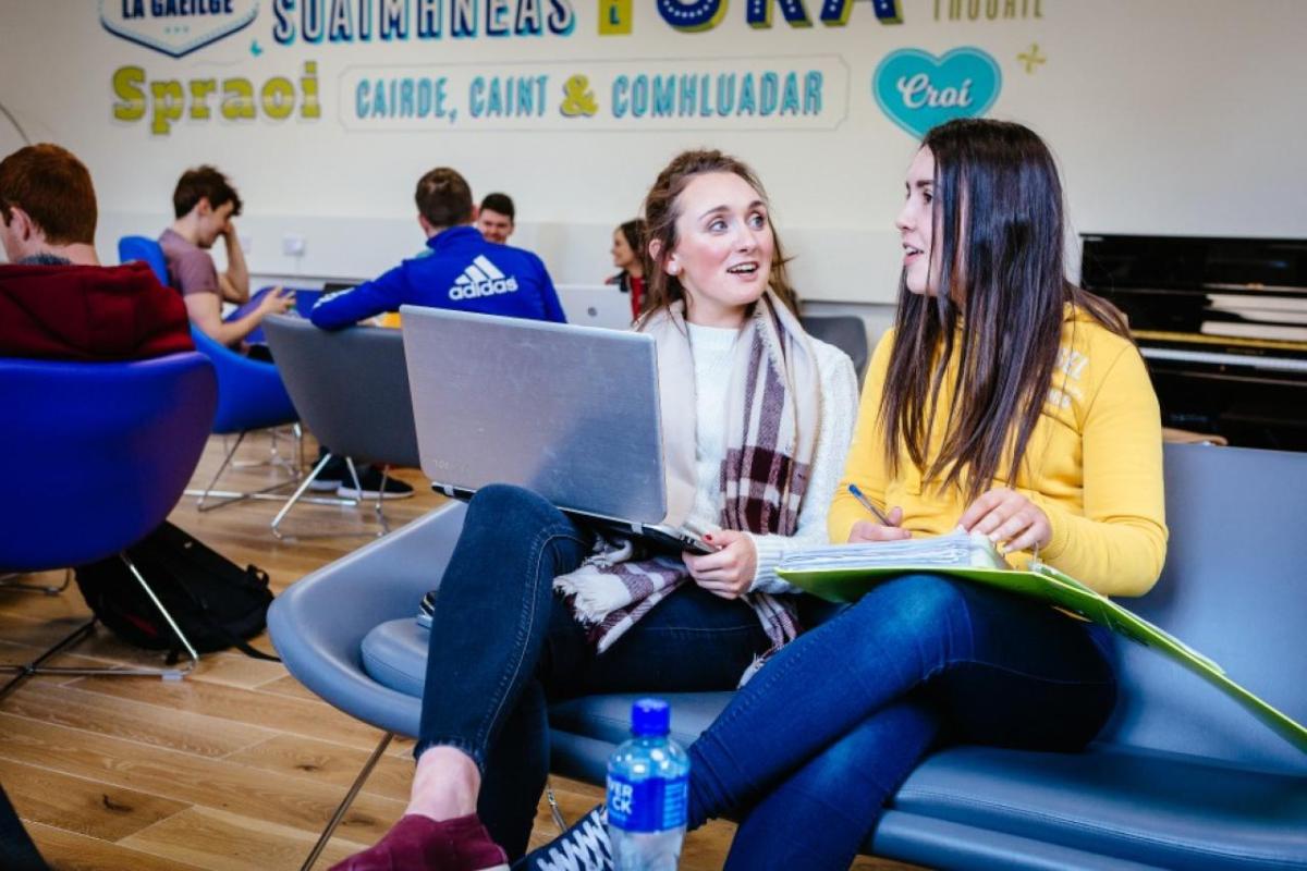 Two students collaborating using a laptop