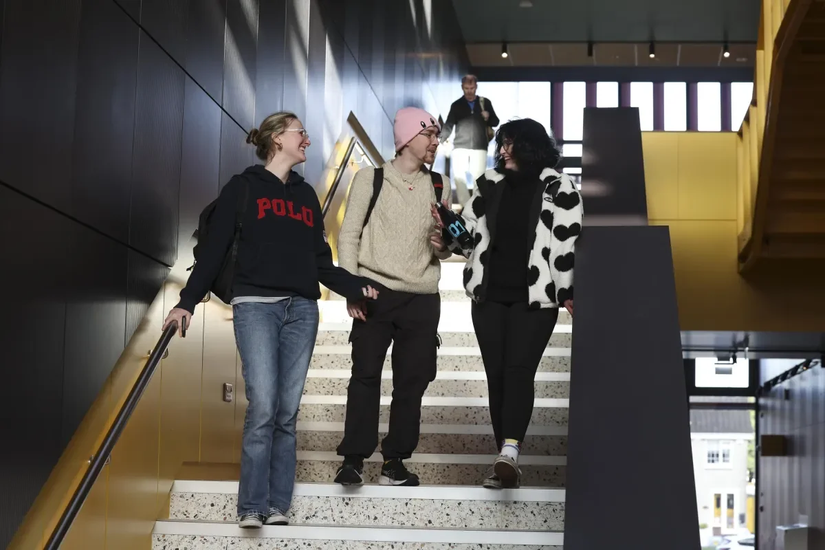 Four students chatting on the stairs in the new Polaris building.