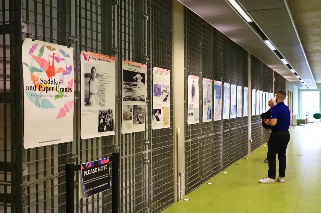 Two men looking at posters hanging on a wall