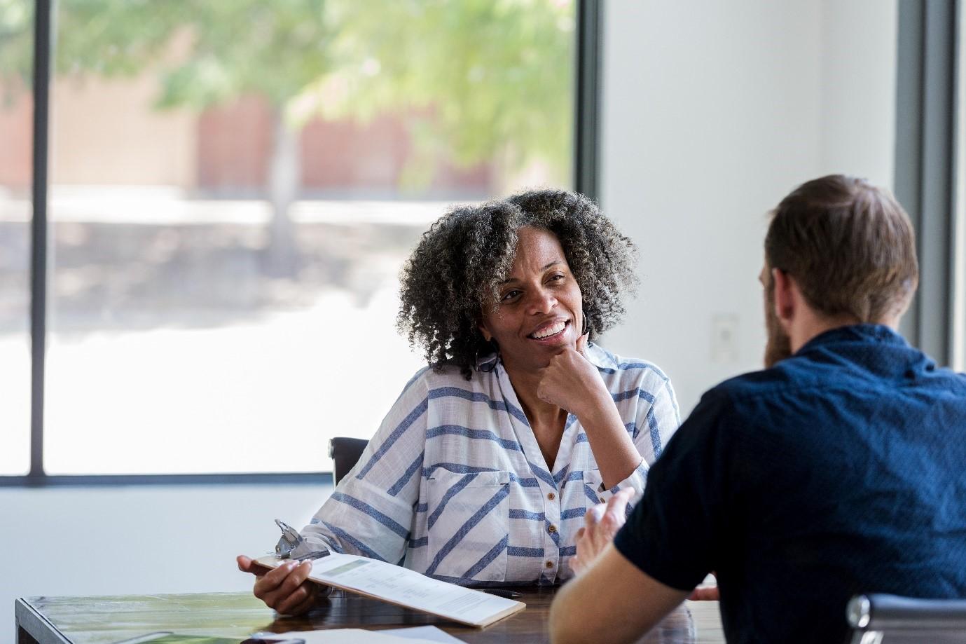 Two people talking by an office window