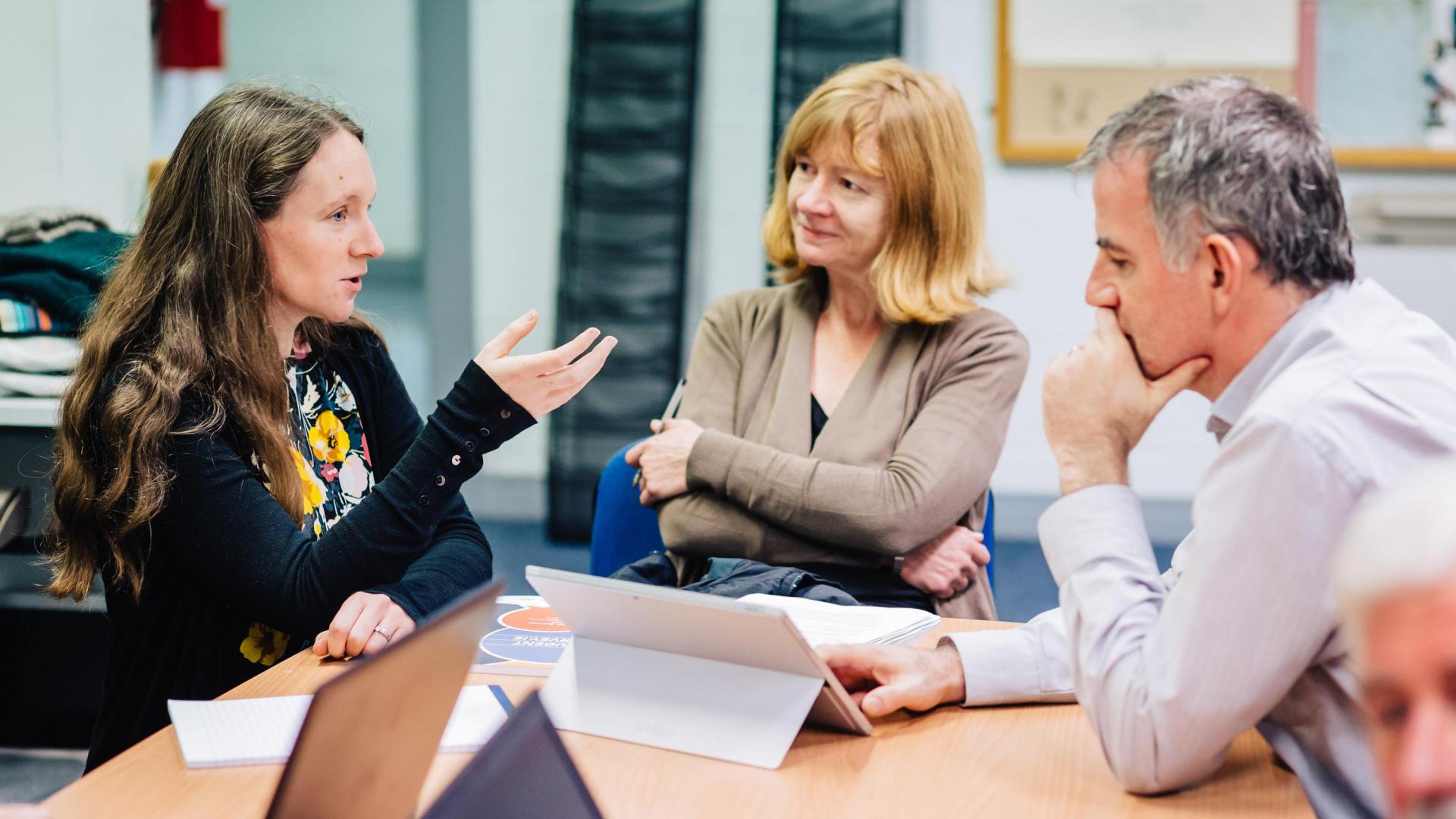Three mature students discussing a task together