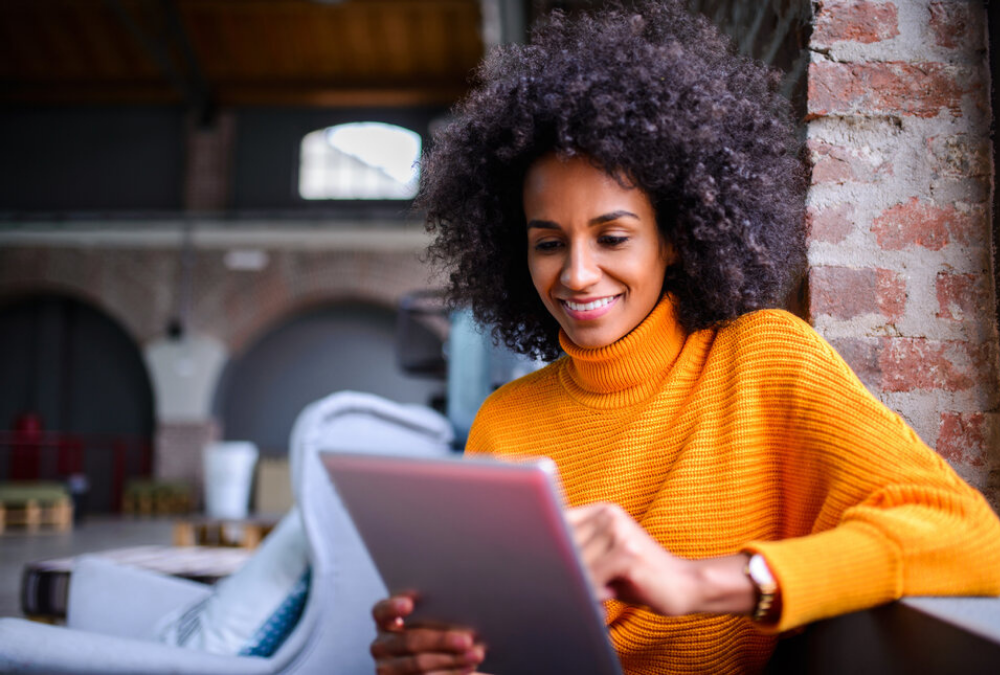 female looking at tablet smiling