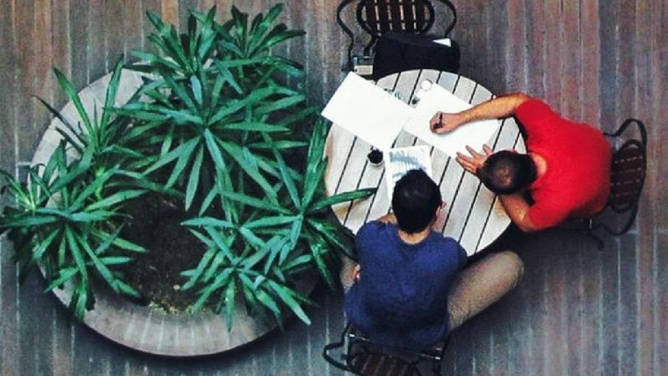 Two people chatting at table, view from above