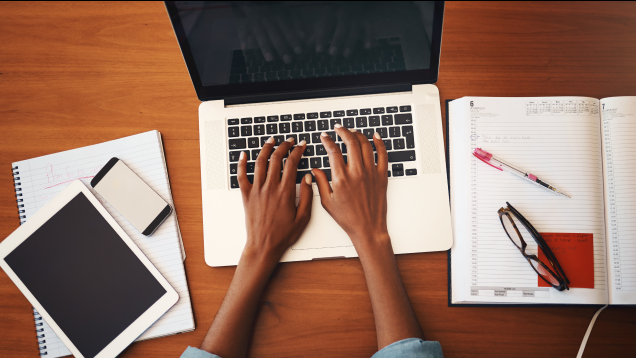 Hands typing on a laptop