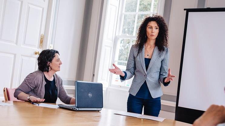 Women standing presenting to room