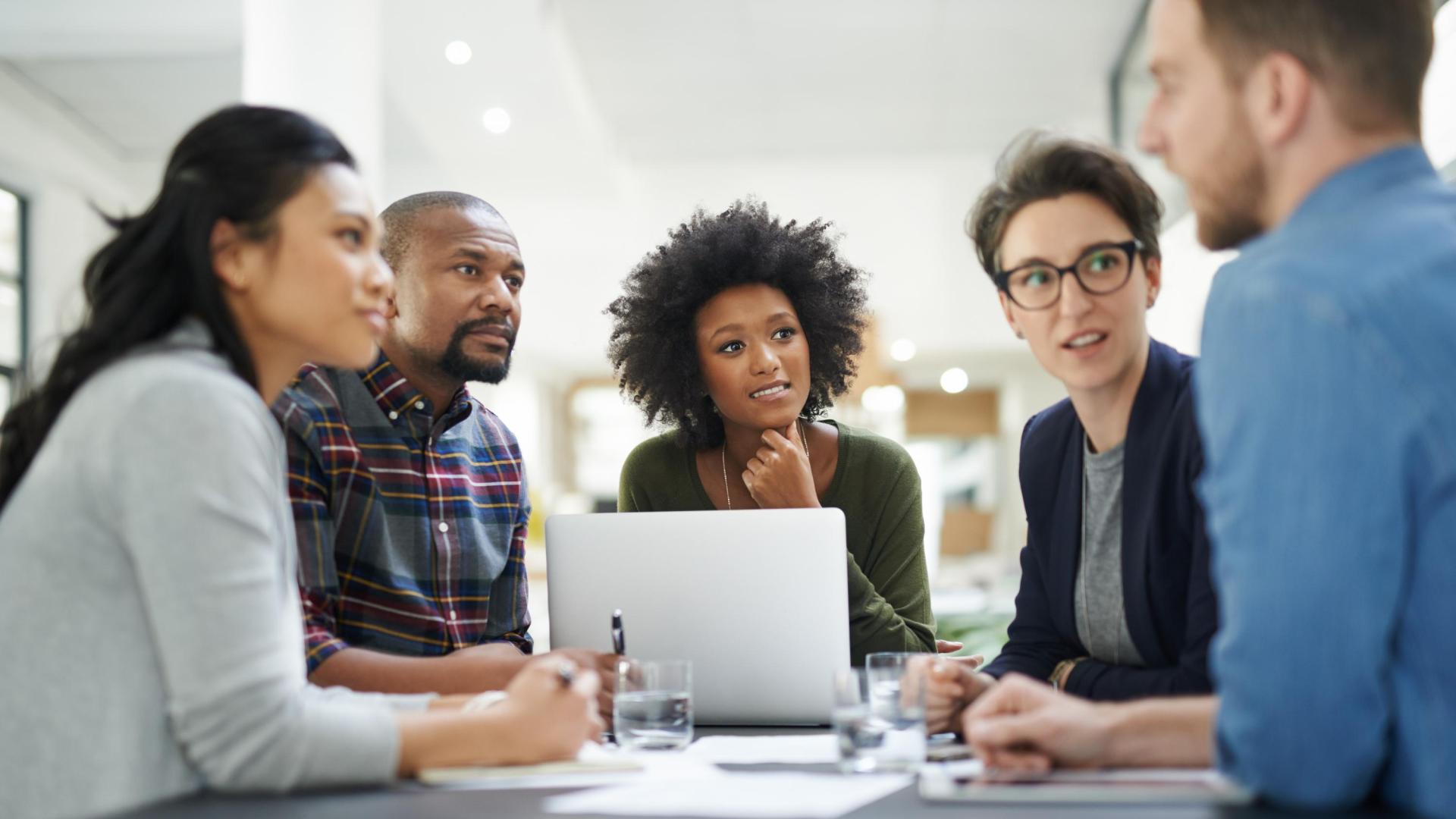 A group of colleagues sitting around a conference table having a discussion.