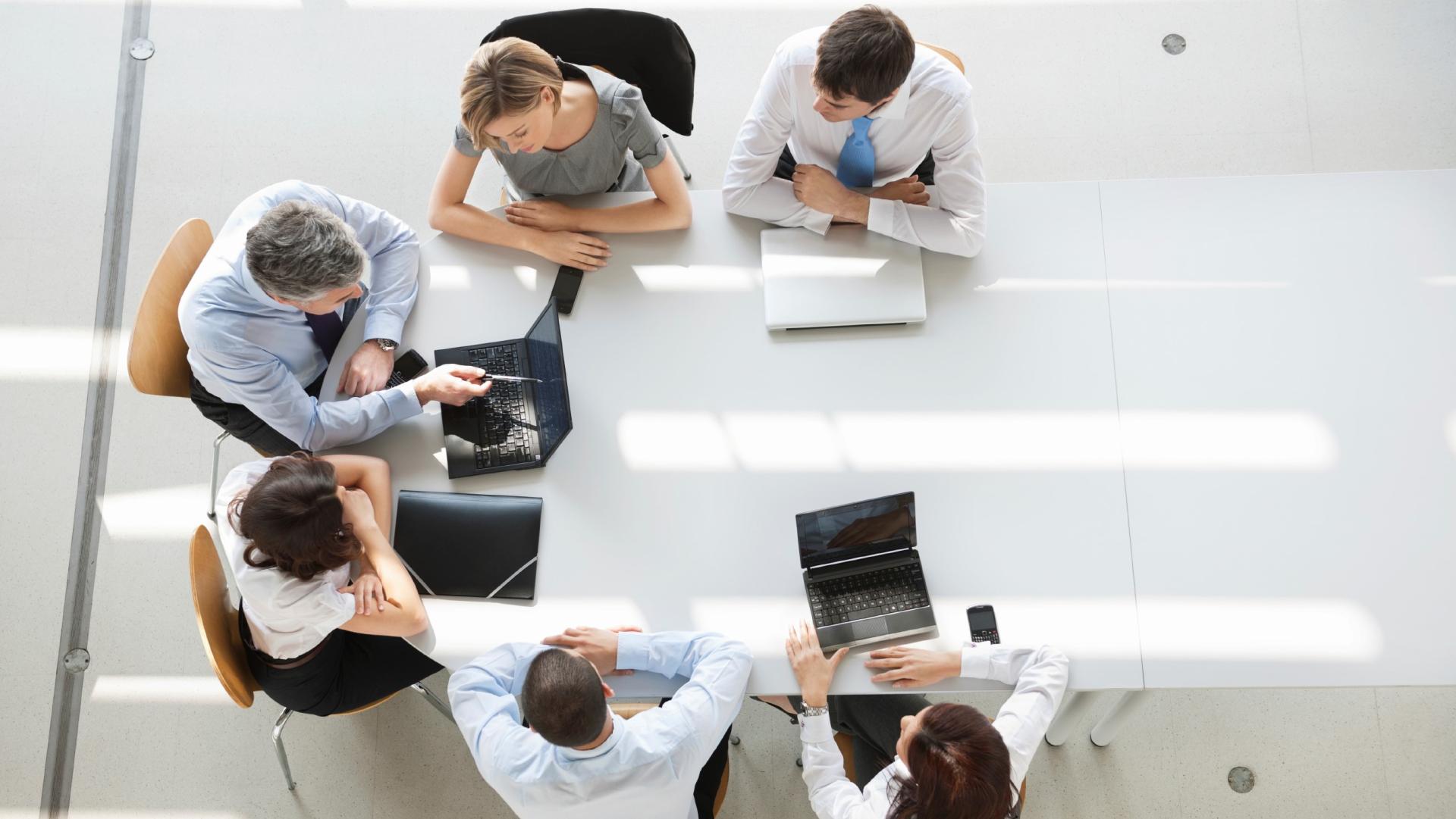 A group of colleagues sitting around a conference table having a discussion.