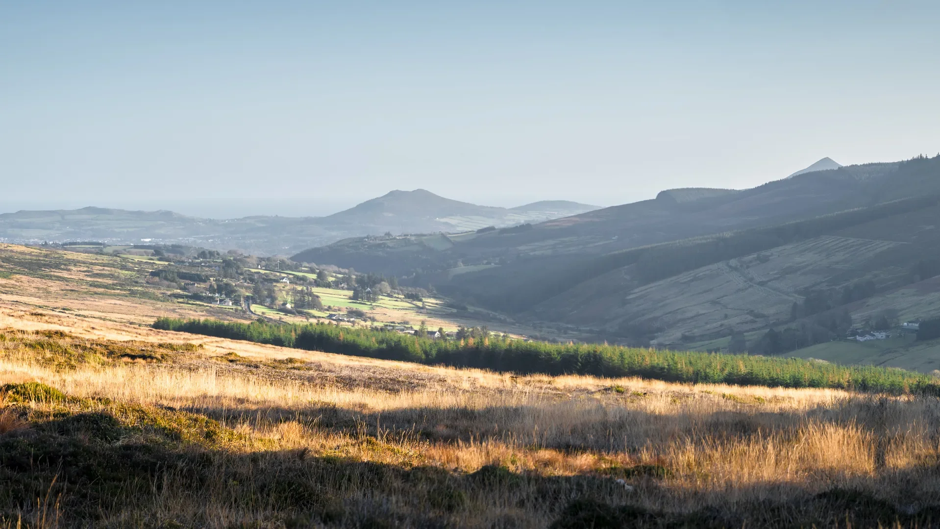 Panoramic landscape scenery along the Dublin and Wicklow mountains walking trail, in winter sunshine and tip of sugarloaf mountain showing in distance