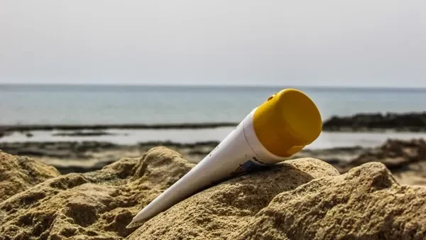 Sunscreen bottle on sandy beach