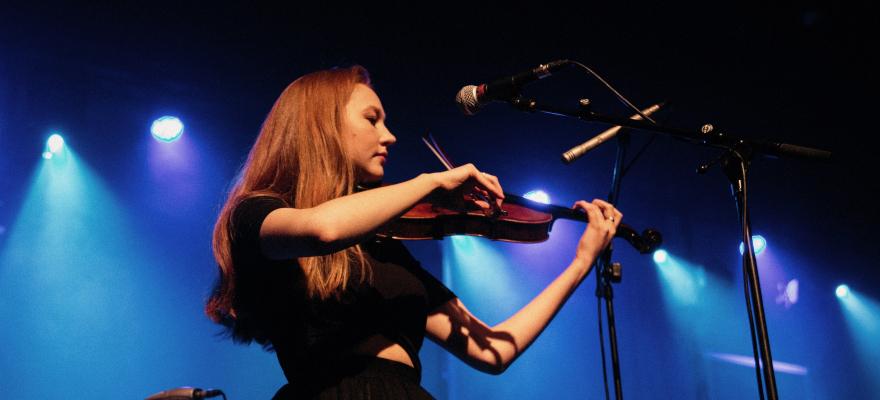 Girl with auburn hair playing fiddle
