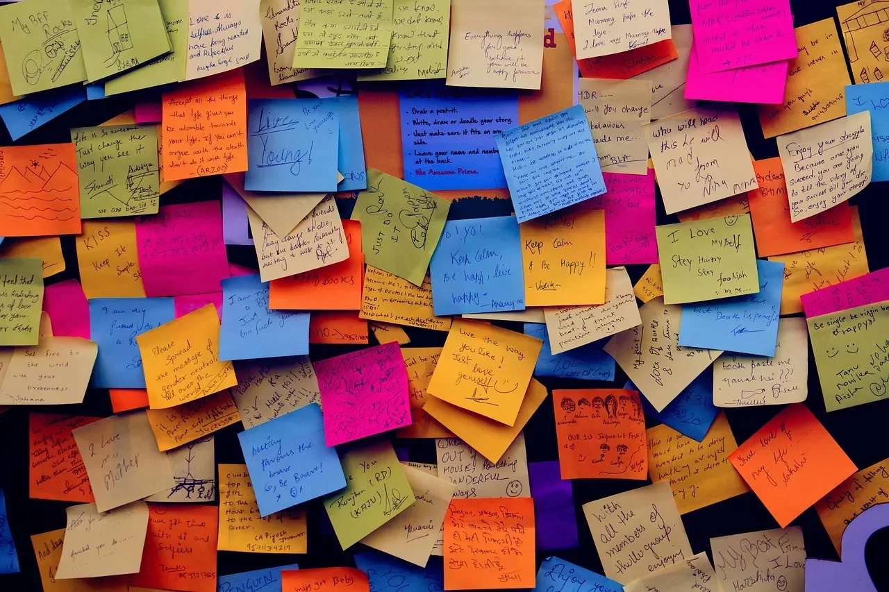Dozens of colourful post it notes stuck to a wall