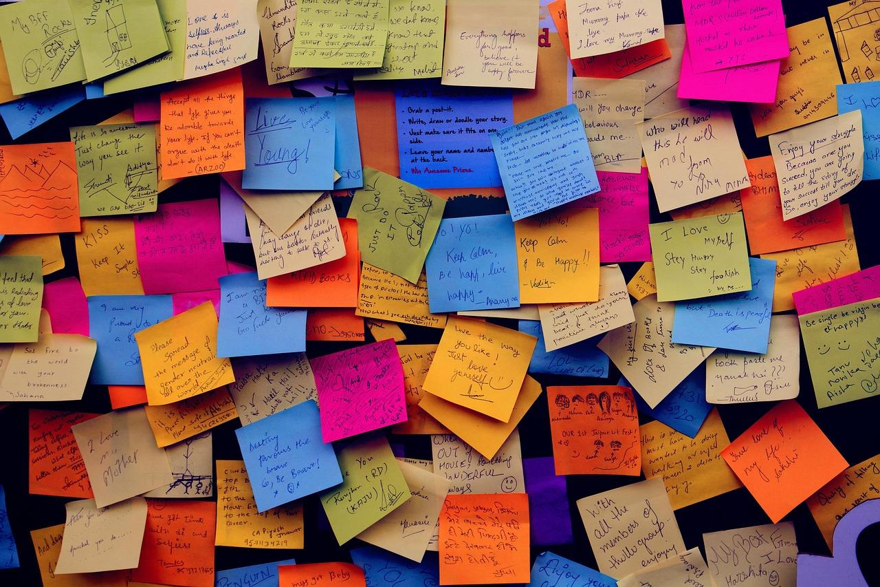 Dozens of colourful post it notes stuck to a wall