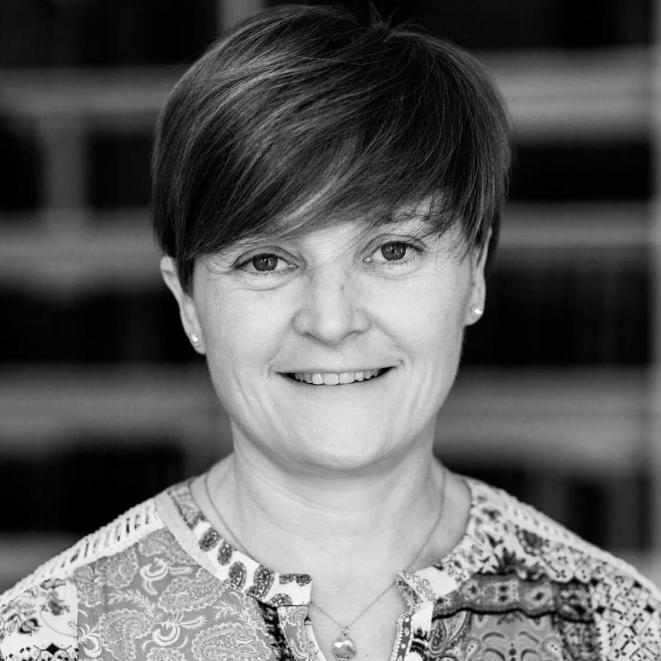 Black and white image of caucasian female with short hair looking straight to camera