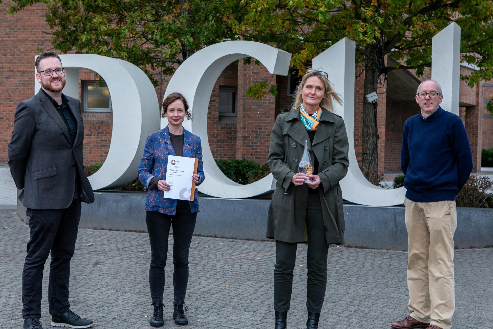 Four staff members from DCU School of Communications with their Athena Swan award