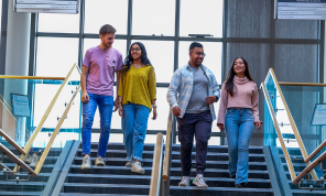Shows four students descending a staircase