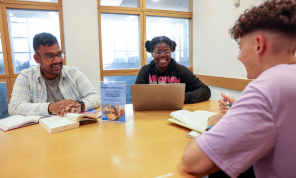 Shows three people sitting around a table