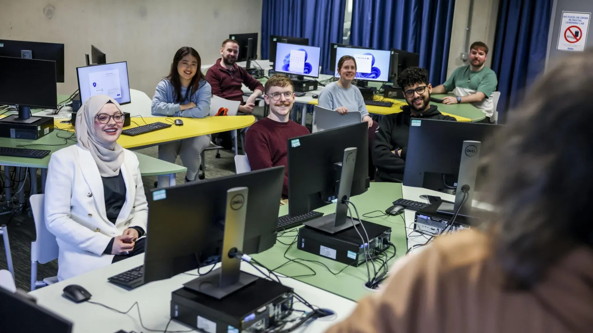 6 students sitting in a computer lab, taking part in a Library information session