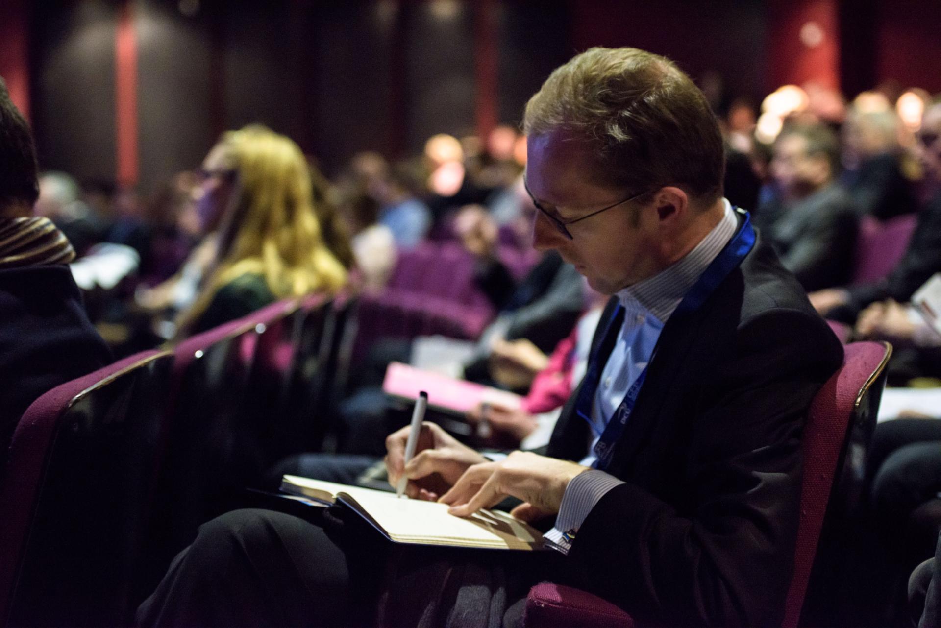 Man taking notes at conference