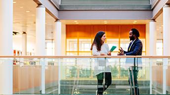  two people talking in the DCU library