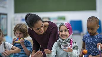 Teacher laughing with children