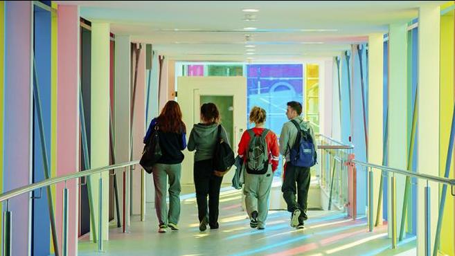 Students walking on indoor bridge