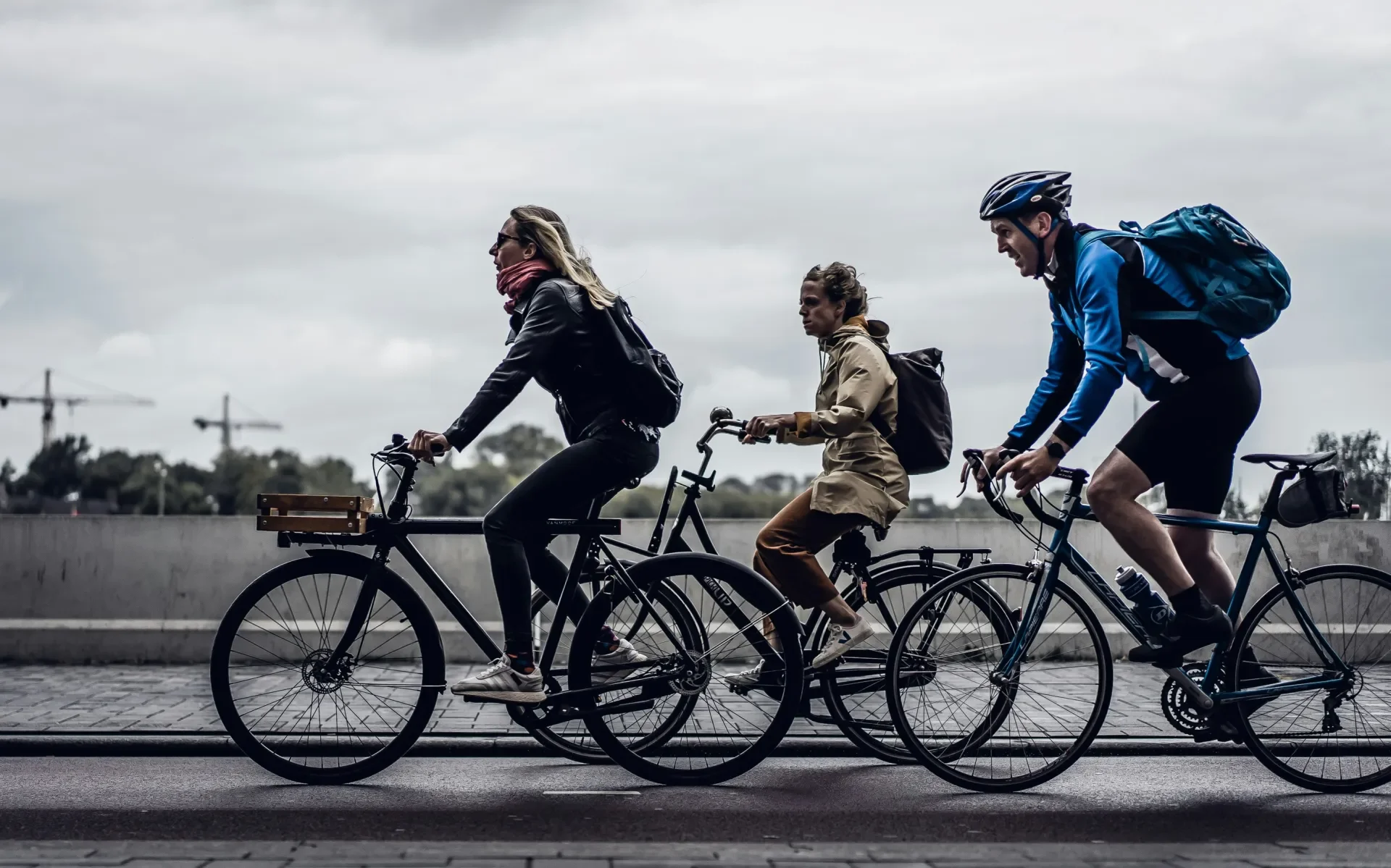 3 cyclists on bikes cycling on a road
